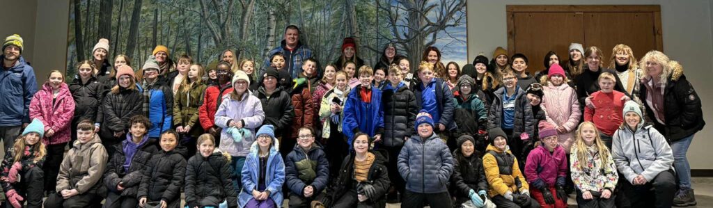 Class picture in front of building mural